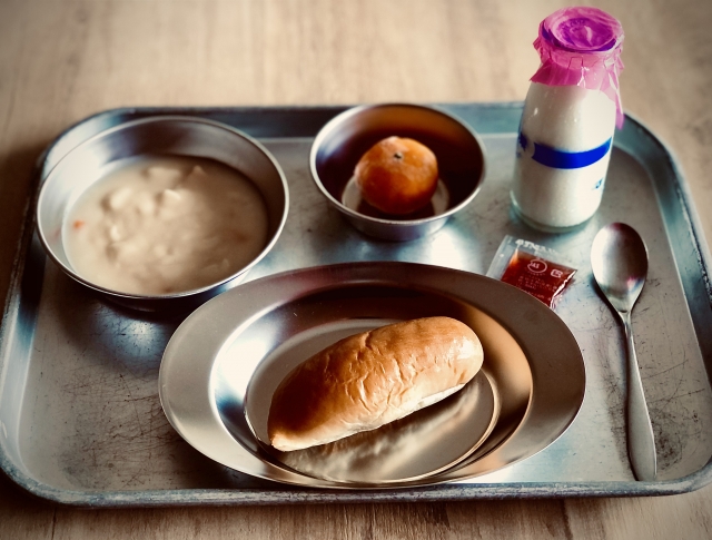 By the mid-20th century, Japanese school lunches had changed from simple meals into a familiar scene of bread, milk, soup, and fruit.