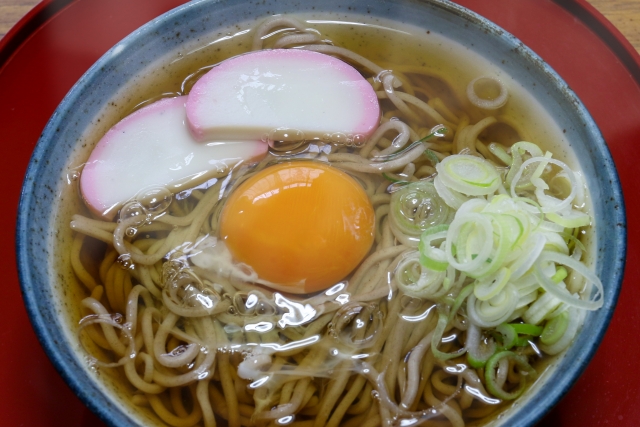 A bowl of traditional Japanese tsukimi soba, hot soba noodles topped with a raw egg